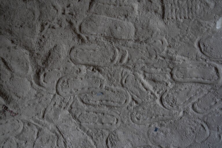 Footprints are visible at Chanaute Market, Melamchi, northeast from Kathmandu, Nepal, Sunday, Sept. 15, 2024, on the sand inside a house damaged by floods in 2021. (AP Photo/Niranjan Shrestha)