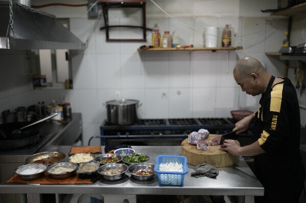 Li Ming prepares food at his son's Chinese food restaurant “Nueve y media,” in the Roma Sur neighborhood of Mexico City, Friday, July 5, 2024. (AP Photo/Eduardo Verdugo)