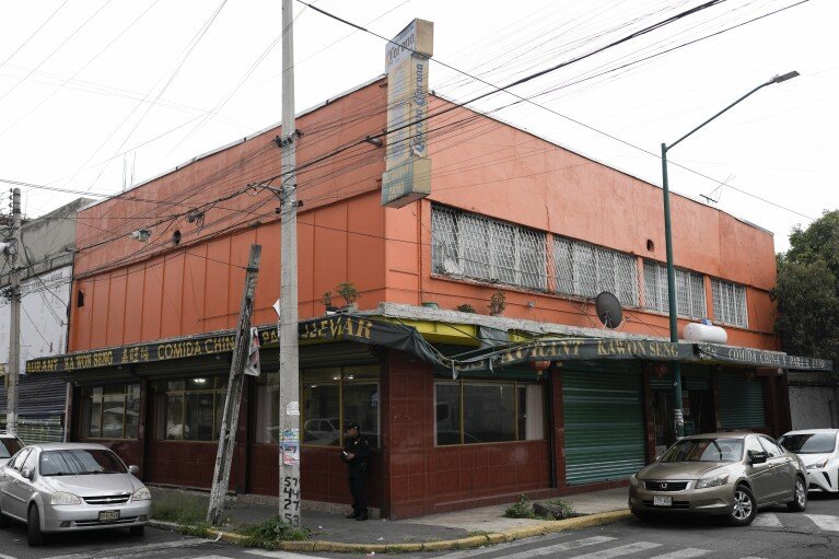 A policeman stands in front of a Chinese restaurant in Viaducto Piedad in Mexico City, Wednesday, July 24, 2024. (AP Photo/Eduardo Verdugo)