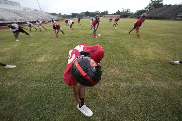 Members of the Baker High football team warm up at practice in Baker, La., Wednesday, Aug. 28, 2024. (AP Photo/Gerald Herbert)