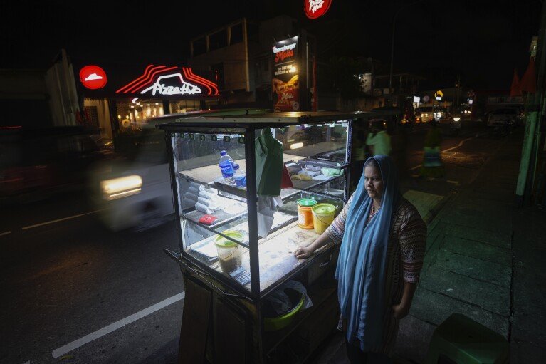 Fathima Shiyama, 48, waits for customers next to her food cart in Colombo, Sri Lanka, Tuesday, Sept. 3, 2024. (AP Photo/Eranga Jayawardena)