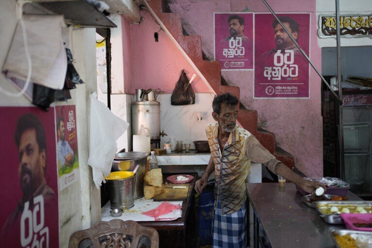 Election posters showing portraits of National People's Power's presidential candidate Anura Dissanayake, are pasted on the kitchen walls of an eatery where a cook prepares food for customers in Colombo, Sri Lanka, Monday, Sept. 16, 2024. (AP Photo/Eranga Jayawardena)