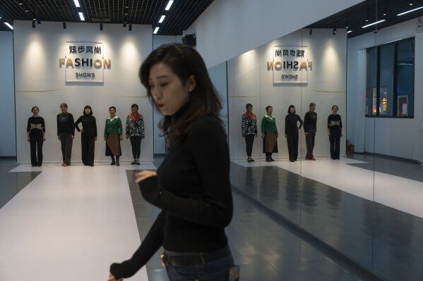 Women line up as they learn how to walk on the catwalk from an instructor during a modeling class at the University for the Elderly in Beijing, Oct. 23, 2024. (AP Photo/Ng Han Guan, File)