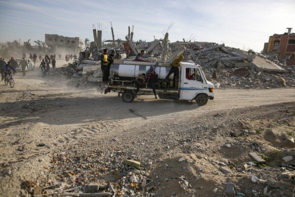 Displaced Palestinians leave parts of Khan Younis as they go back to their homes in Rafah, southern Gaza Strip, Sunday, Jan. 19, 2025. (AP Photo/Jehad Alshrafi)
