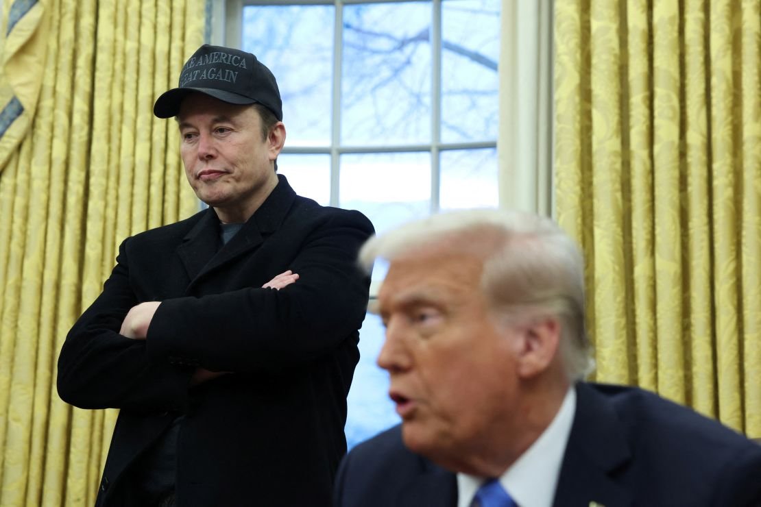 Elon Musk listens to President Donald Trump speak in the Oval Office of the White House.
