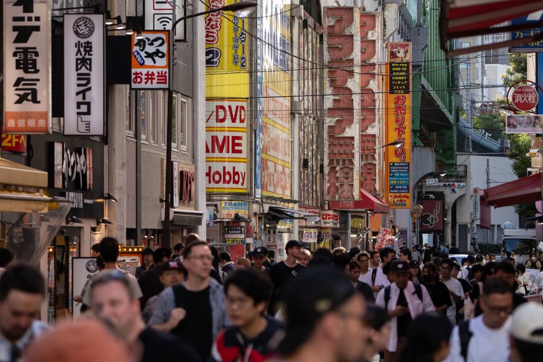 People walk through Tokyo's Akihabara district, famous for its extensive selection of electronics, anime, manga and gaming merchandise.