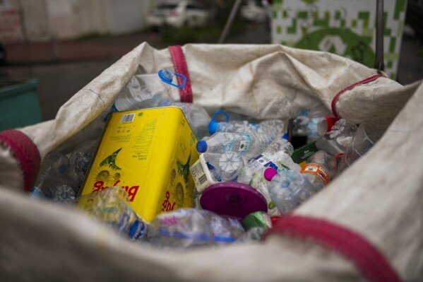 A cart mostly full with plastic bottles is parked in Istanbul, Turkey, Sunday, Feb. 9, 2025. (AP Photo/Francisco Seco)