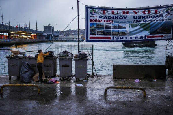 A man looks for plastic items at Karakoy ferry terminal in Istanbul, Turkey, Sunday, Feb. 9, 2025. (AP Photo/Francisco Seco)