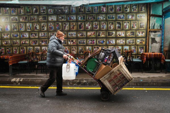 A man pushes his cart with discarded plastic items and cartons at Kadikoy district in Istanbul, Turkey, Sunday, Feb. 9, 2025. (AP Photo/Francisco Seco)