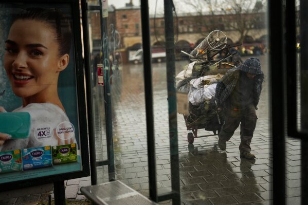 A man pulls a trolley with discarded metal items in Istanbul, Turkey, Thursday, Feb. 6, 2025. (AP Photo/Francisco Seco)
