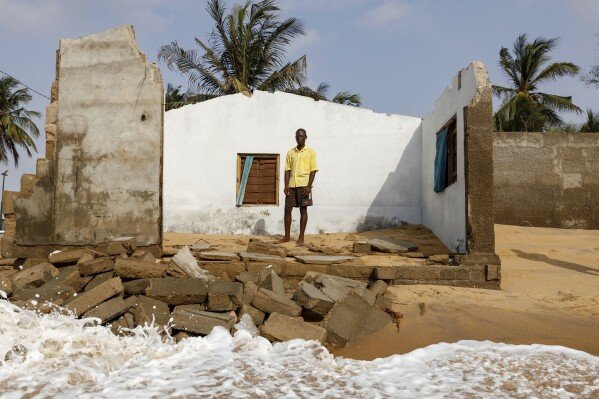 Atsu Godslove Afeli poses for a portrait in his room in his family home that was destroyed by coastal erosion in Avegadzi, Ghana, Wednesday, March 5, 2025 (AP Photo/Misper Apawu)
