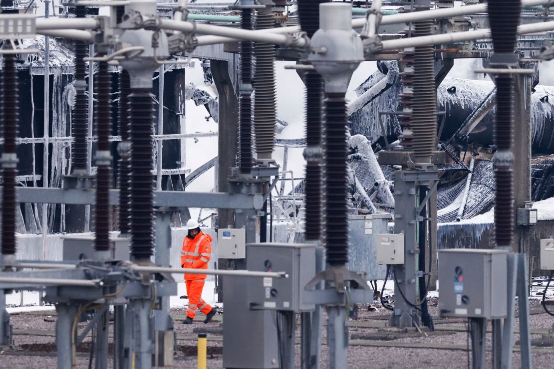 A staff member walks past a substation supplying power to Heathrow Airport where a fire broke out in Hayes, west London on March 21, 2025.